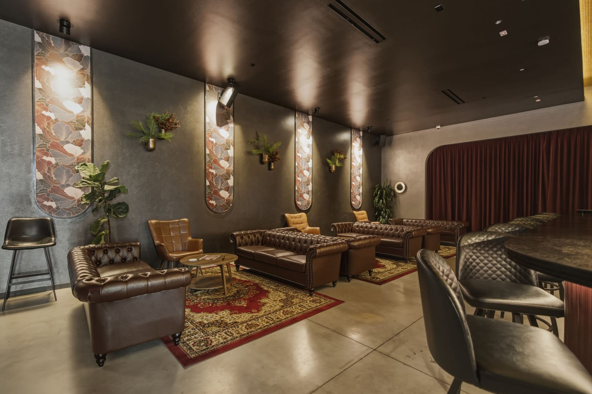 The Assembly Icehouse lounge, empty — leather seating, botanical panels and low light